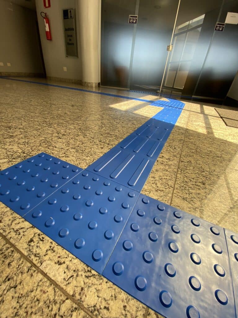 Piso tátil alerta e direcional próximo ao elevador